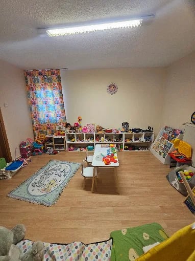 Oyun terapisi odasında sarı çadır, kum kabı ve peluş oyuncak köşesi